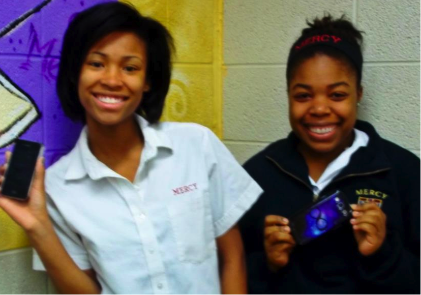 During the morning rush, senior AJ Slaughter (left) and junior Brianna McClendon (right) happily show off their phones in the media center.