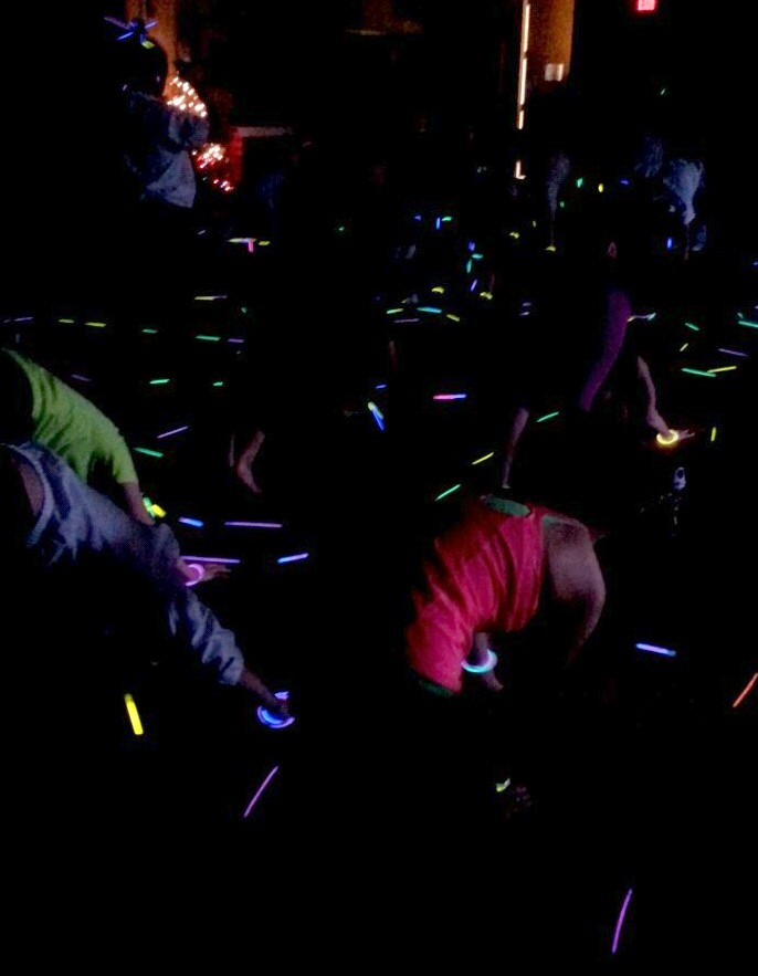 Caption: Freshmen bend and stretch in the "downward-facing dog" pose during Link Crew's December Glowga event. 